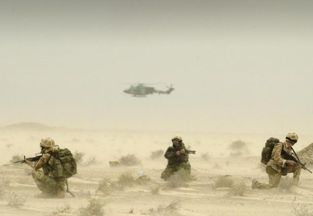 FILE PHOTO: Soldiers attached to Britain's 3 Army Air Corps patrol the desert around the oil fields of north Ramaila in Iraq