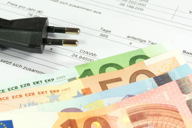 Die Netzentgelte werden 2026 nicht mehr so stark steigen wie zuletzt. Stromrechnung mit Geldscheinen und Netzstecker.