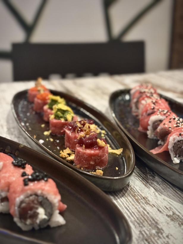 Fleisch-Sushi auf feinen Tellern.