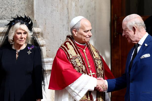Britain's King Charles and Queen Camilla make their first state visit to the Holy See since Pope Leo XIV's election König Charles III. schüttelt dem Papst in roter und goldener Robe die Hand, während Königin Camilla daneben steht.