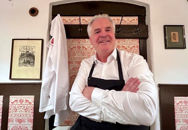 Der Wirt blickt in die Kamera.