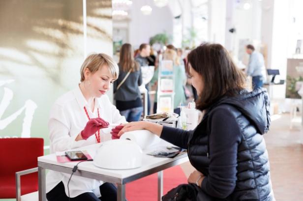 Eine Frau lässt sich in einem Nagelstudio die Nägel machen.