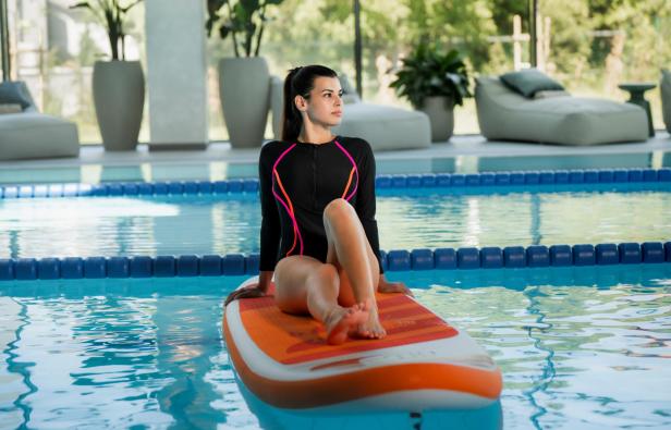 Eine Frau in einem Badeanzug auf einem Schlauchboot in einem Pool 
