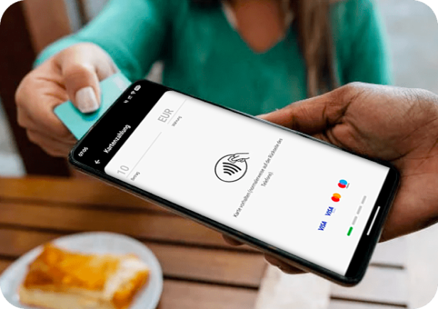Eine Frau hält ihre Visakarte an ein mobiles Zahlungsgerät.