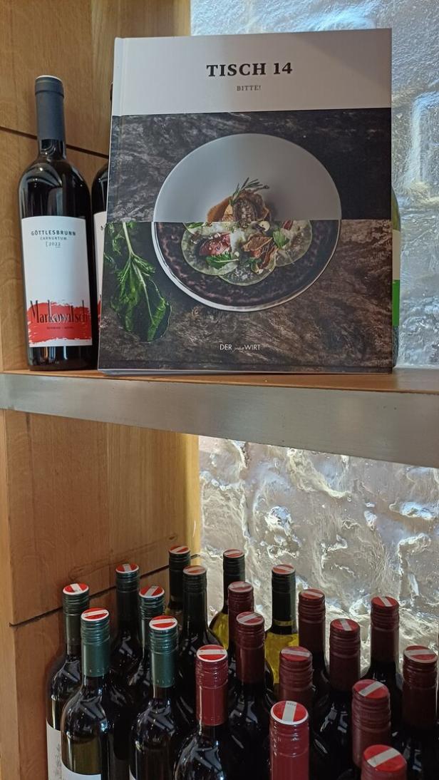 Das Kochbuch von Johannes Jungwirth ist im Regal im Wirtshaus aufgestellt.  Genauso wie viele Weinflaschen. 