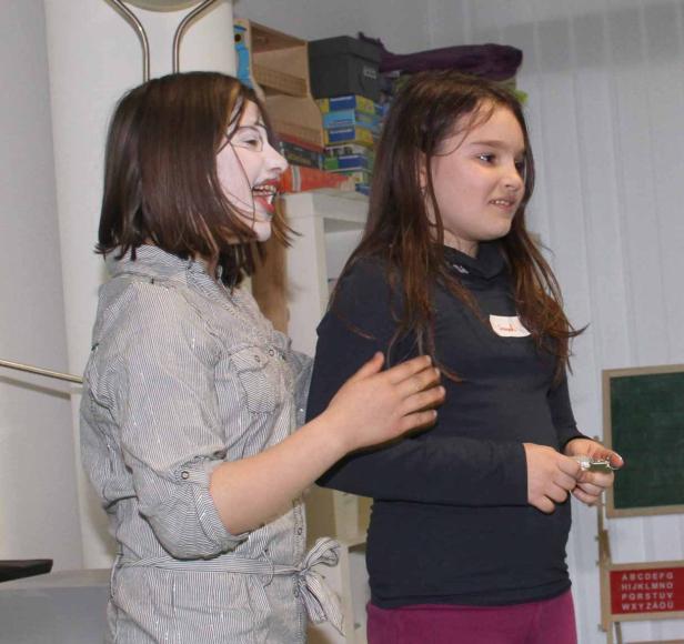 Zwei Mädchen stehen nebeneinander, eines davon mit weißem Gesicht und rotem Lippenstift.