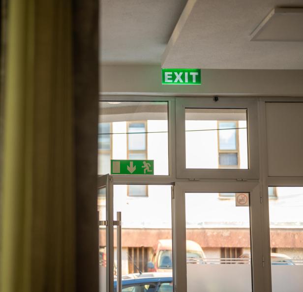 Zwei leuchtend grüne Exit-Schilder hängen über den Türen.