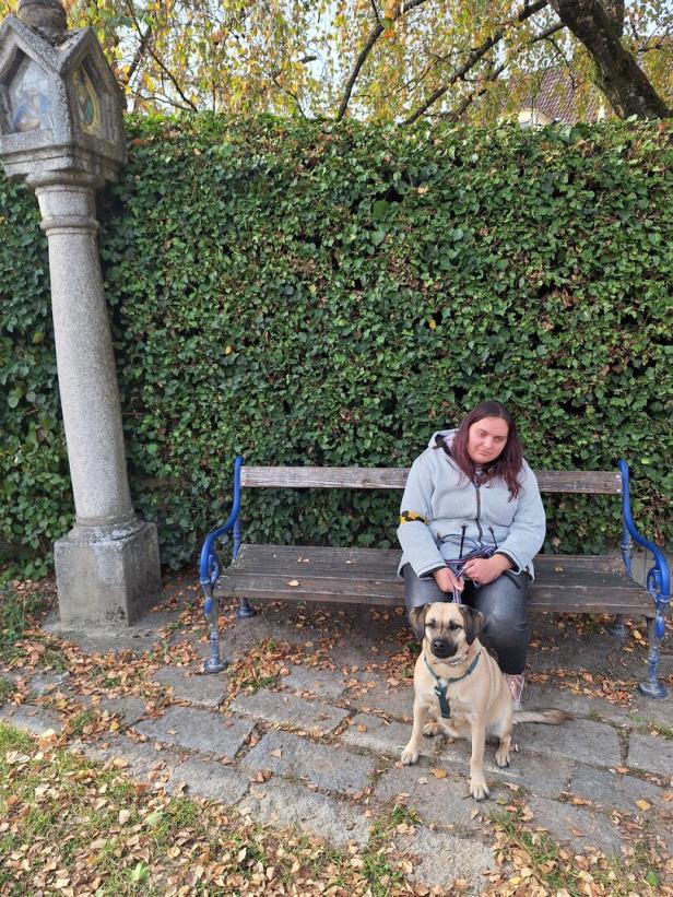 Blinde Frau mit Hund auf einer Parkbank