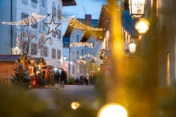 Man sieht die Gassen der Kitzbüheler Innenstadt mit weihnachtlicher Beleuchtung und Ständen des Kitzbüheler Adventmarktes.