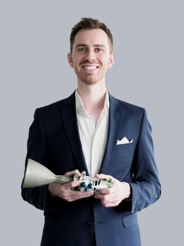 Ein Mann hält einen Raketenantrieb in den Händen