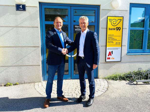 Zwei Männer vor einer Post-Filiale.