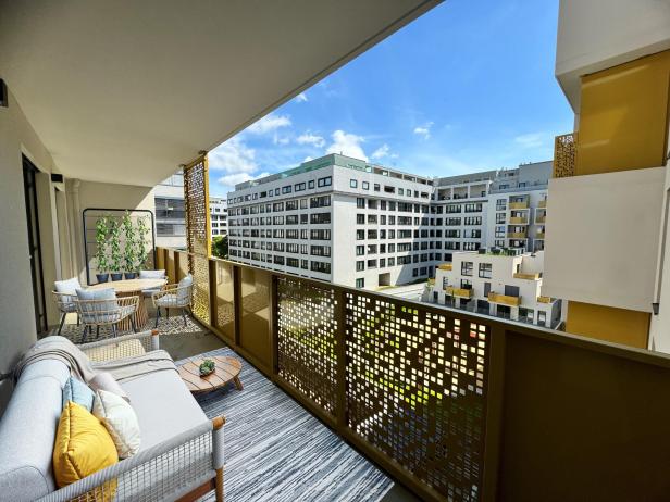 Ein gemütlich möblierter Balkon mit Aussicht auf die umliegenden Wohnhäuser.