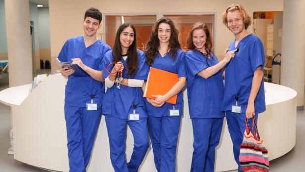 junge pfelgerinnen und pfleger in blauer kleidung