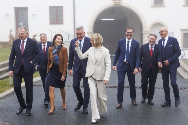 Mehrere Männer und Frauen gegen nebeneinander, im Hintergrund ein Schloss