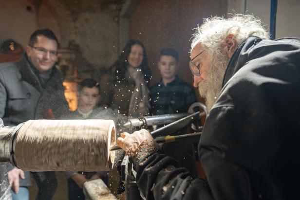 Ein alter Mann beim Handwerk und Zuschauern 