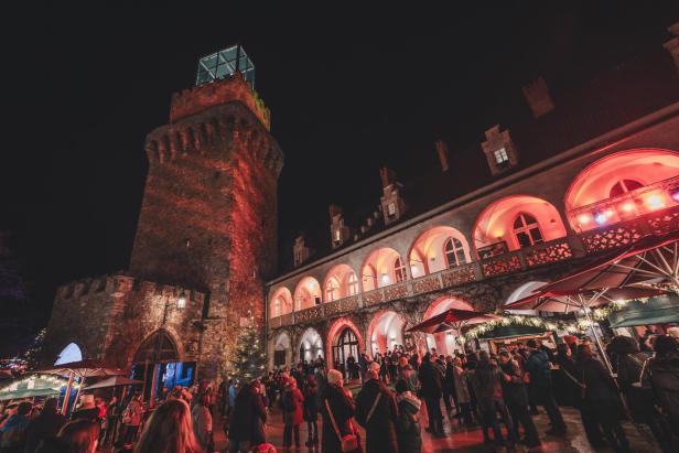 Eine Kirche im roten Licht von einem Weihnachtsmarkt 