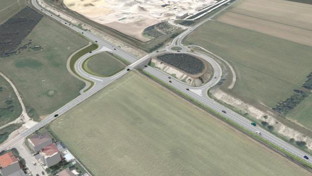 Luftaufnahme einer Autobahnkreuzung mit Feldern und einem Kieswerk im Hintergrund.