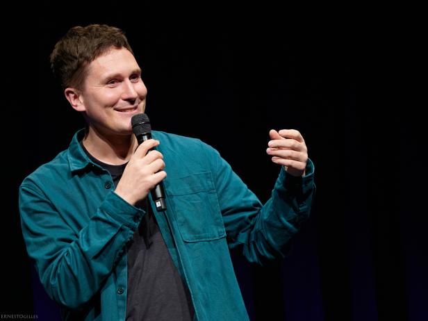 Mann mit Mikrofon auf einer Bühne