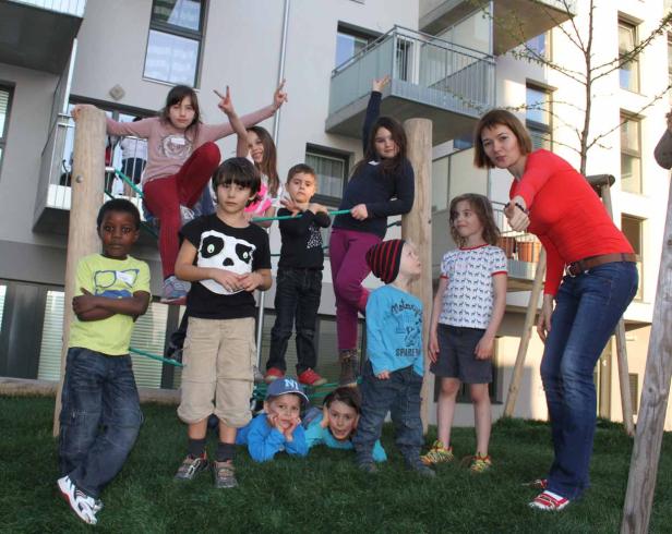 Eine Gruppe von Kindern und eine Frau posieren auf einem Spielplatz für ein Foto.