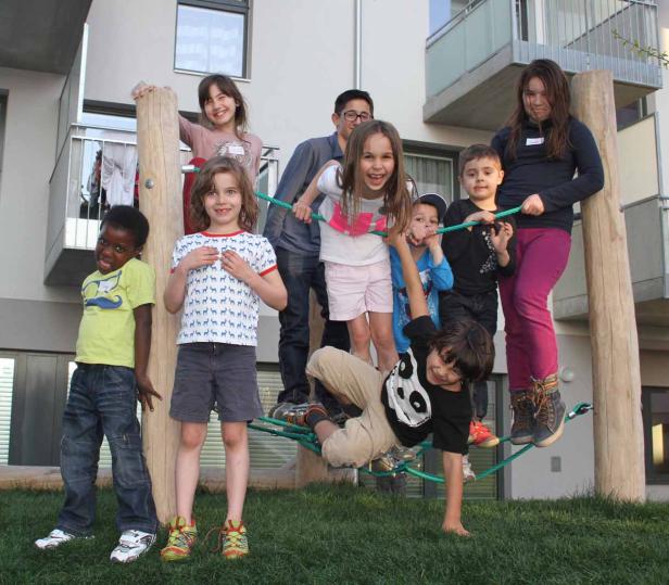 Eine Gruppe Kinder spielt auf einem Klettergerüst im Freien.