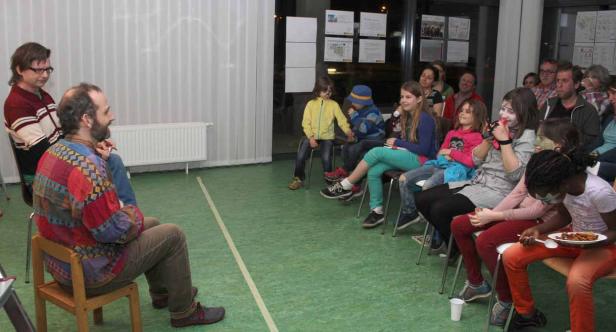 Ein Mann erzählt einer Gruppe von Kindern eine Geschichte.