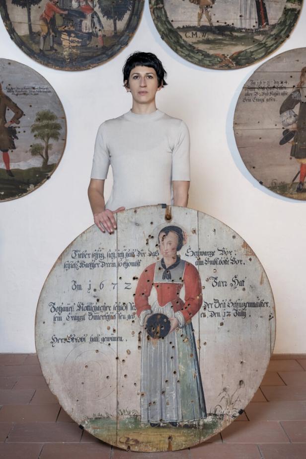 Frau hält eine historische Schießscheibe