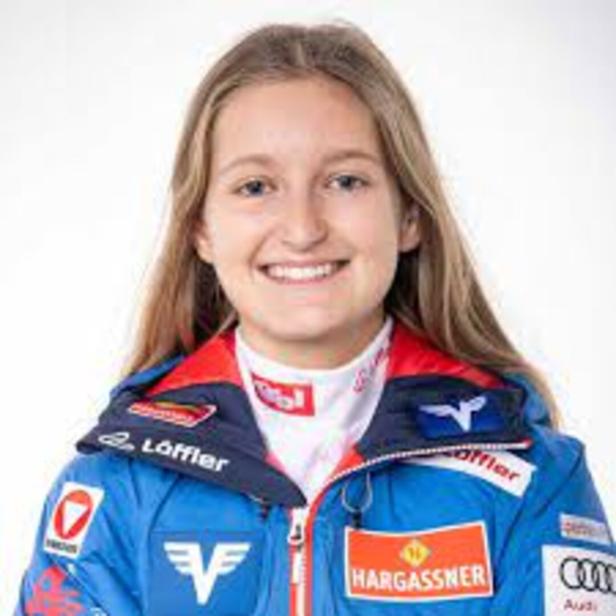 Junge Frau in Sportkleidung lacht in die Kamera