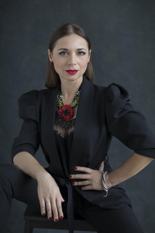 Frau im schwarzen Kleid vor dunklem Hintergrund