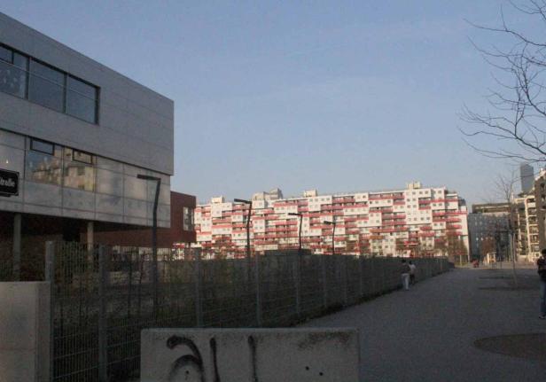 Ein großes Wohngebäude mit roten Balkonen in Wien.