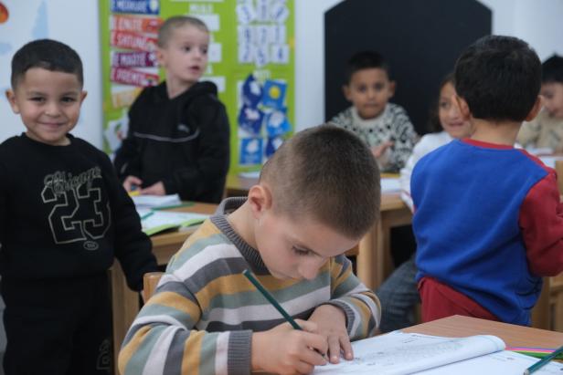 Mehrere Kinder sitzen in einem Klassenzimmer.