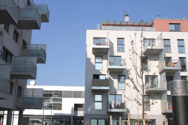 Mehrere moderne Wohngebäude mit Balkonen unter blauem Himmel.