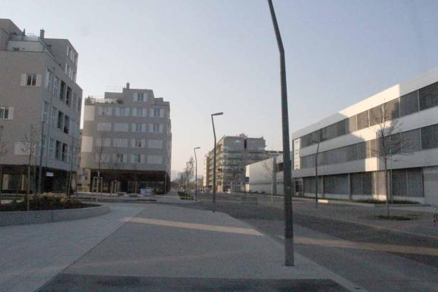 Eine moderne Straße mit Bürogebäuden und Wohnhäusern an einem sonnigen Tag.