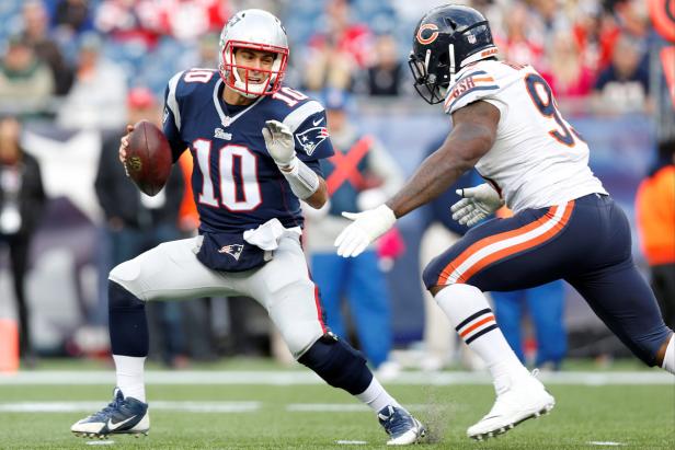 Ein Quarterback der New England Patriots läuft mit dem Ball, verfolgt von einem Spieler der Chicago Bears.