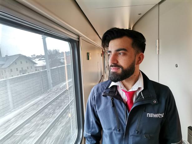 Ein Zugbegleiter schaut aus dem Fenster des Nachtzugs.