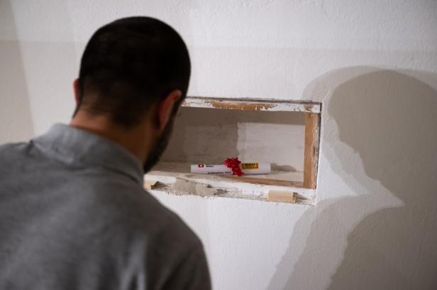 Ein Mann arbeitet an einer Mauer.