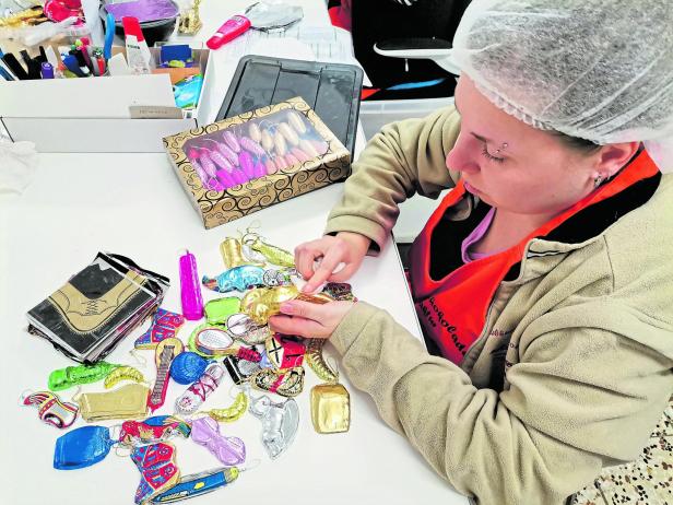 Eine Frau verpackt Christbaumschmuck aus Schokolade..