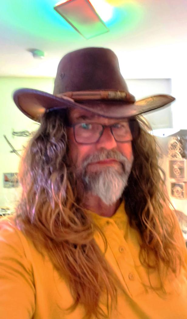 Ein Foto von dem Veranstalter mit Hut und Perücke.