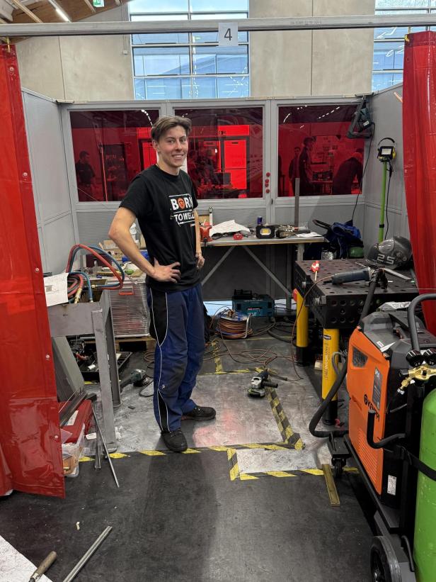 Ein Mann steht zwischen Technik-Geräten. 