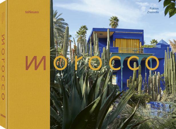 Das Buchcover zeigt "Morocco" vor einem blauen Gebäude und üppigen Pflanzen.