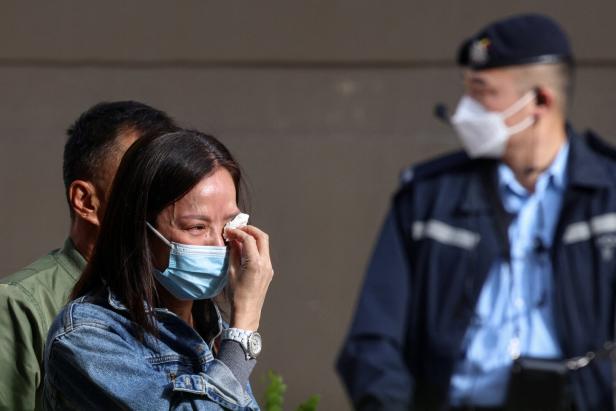 A relative reacts before identifying a family member from photos at Kwong Fuk Community Hall following the Wang Fuk Court housing estate fire, in Tai Po, Hong Kong