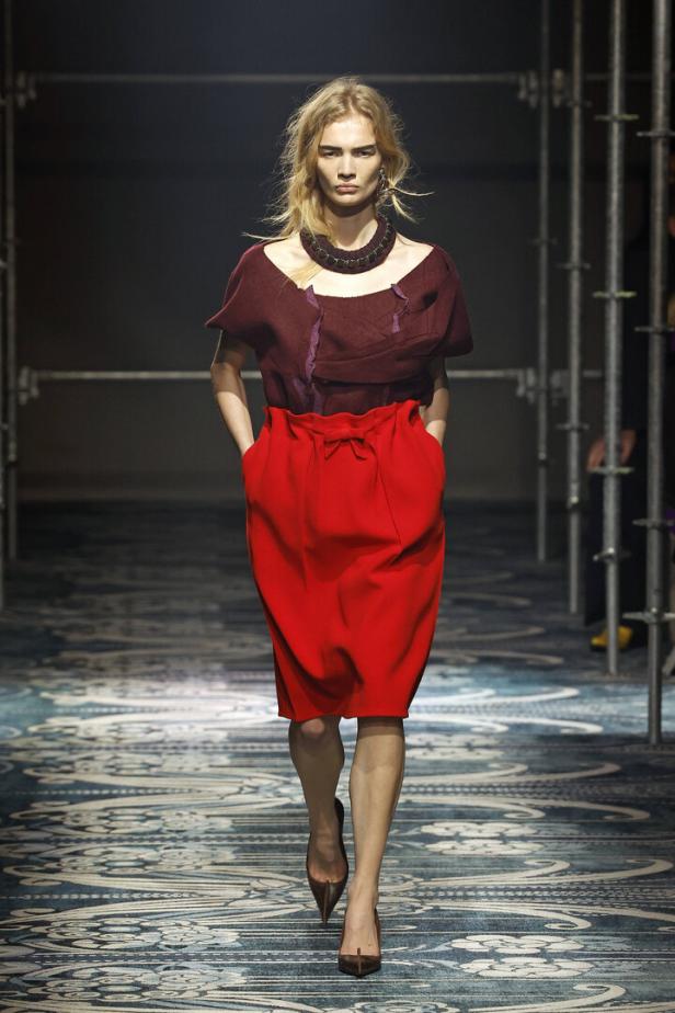 Eine Frau in roter Bluse und knallrotem Rock