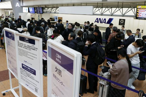 Passengers queue at ANA cancellation counter after the company cancelled flights due to the Airbus A320 recall at Haneda aiport in Tokyo, Japan