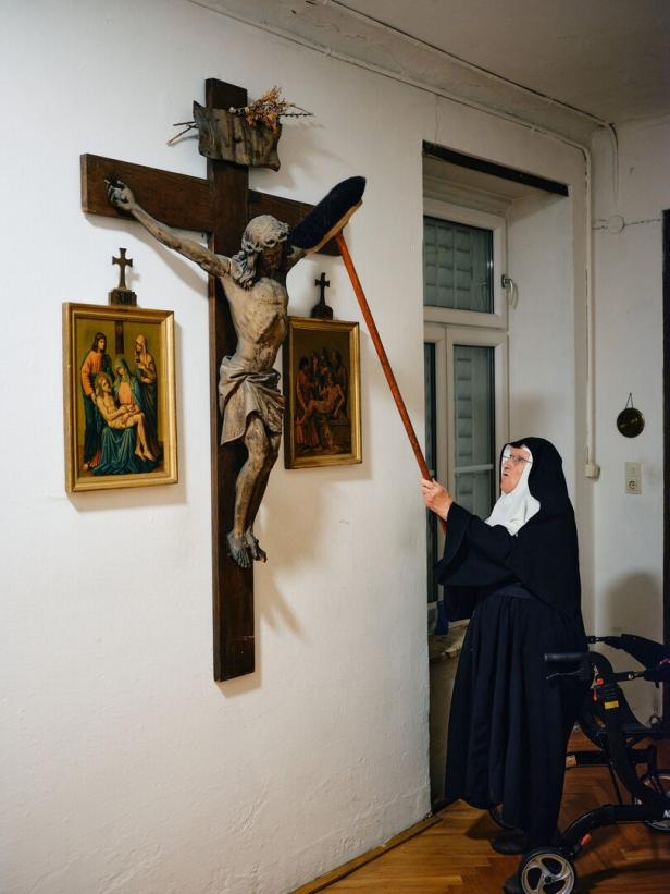 Nonne staubt Kreuz ab