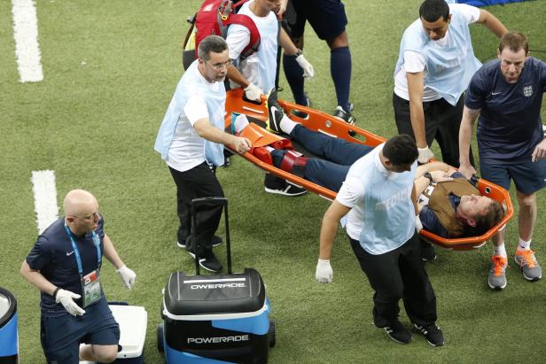 Sanitäter tragen einen verletzten Mann auf einer Trage vom Spielfeld.