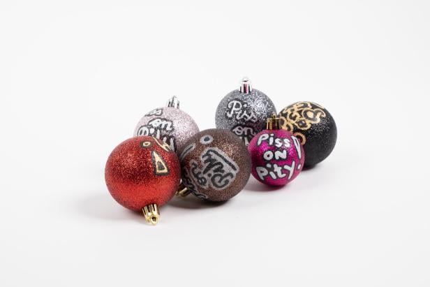 Piss on pity, also "Scheiß auf Mitleid" steht auf Christbaumkugeln.