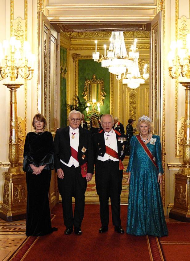Ein festlich gekleidete Gruppe, darunter Steinmeier und König Charles, posiert in einem opulenten Raum.