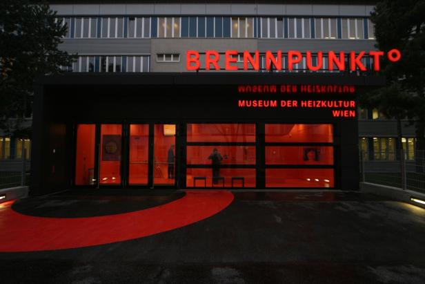 Das Museum der Heizkultur Wien leuchtet rot unter dem Schriftzug "Brennpunkt".