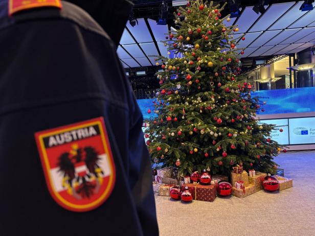 Eine Aufnahme von dem festlich Geschmückten Christbaum und die Schulter eines Feuerwehrmanns.