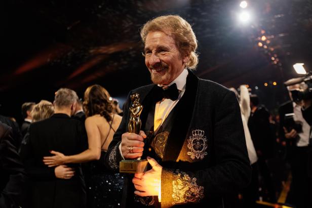 Blonder Mann mit goldener Statuette