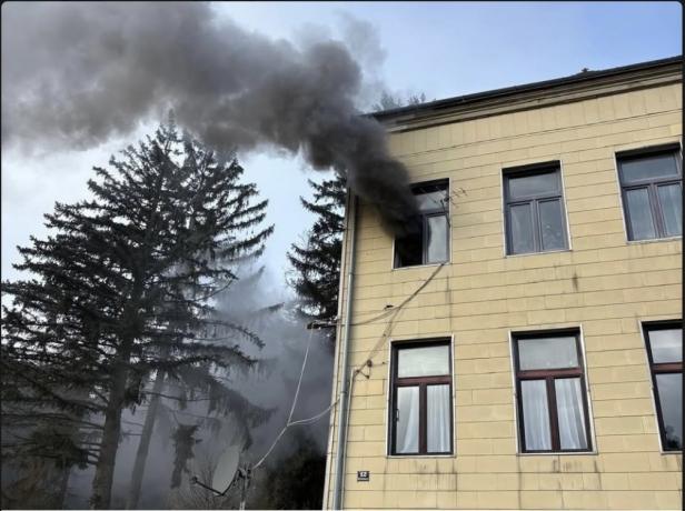 Dichter Rauch dringt aus einem Fenster eines Mehrparteienhauses.